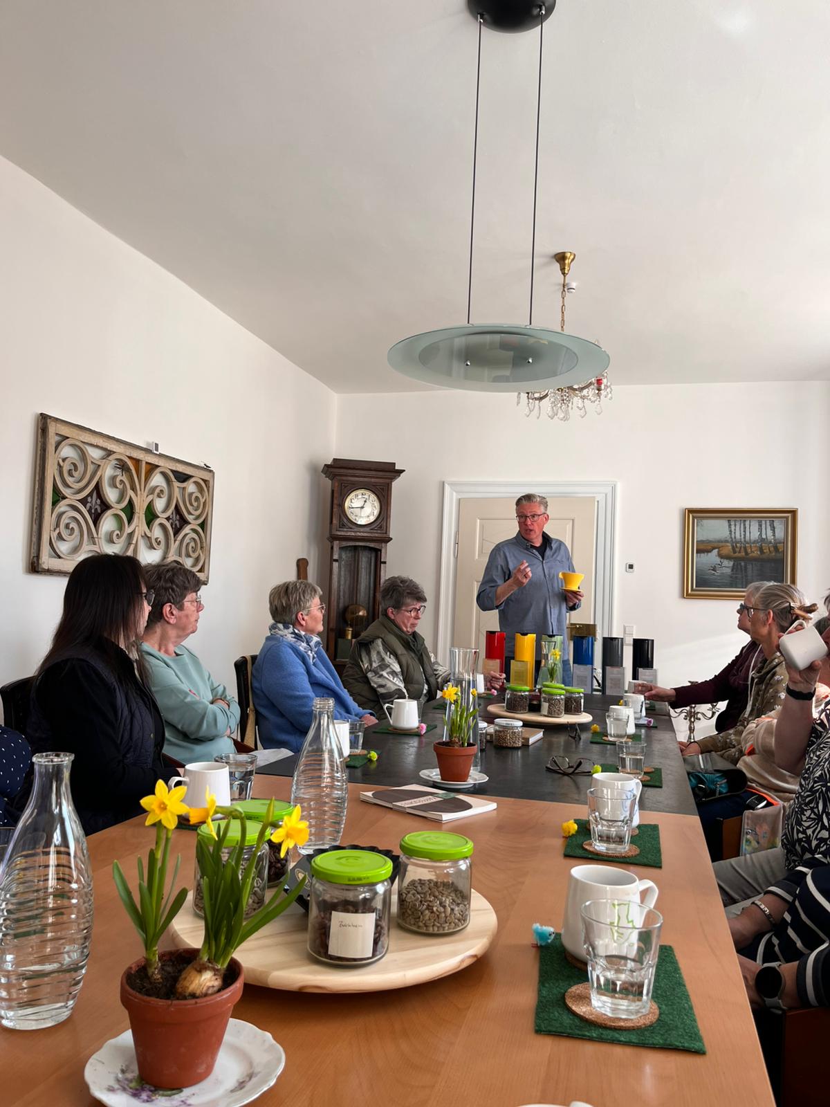 Ein Mann hält einen Vortrag  Am Tisch sitzen mehrere Frauen 
